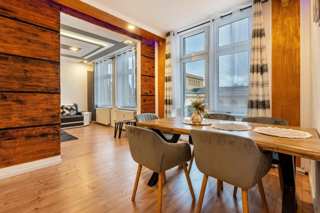 a dining room with a wooden table and chairs at Gera Apartment in Gera