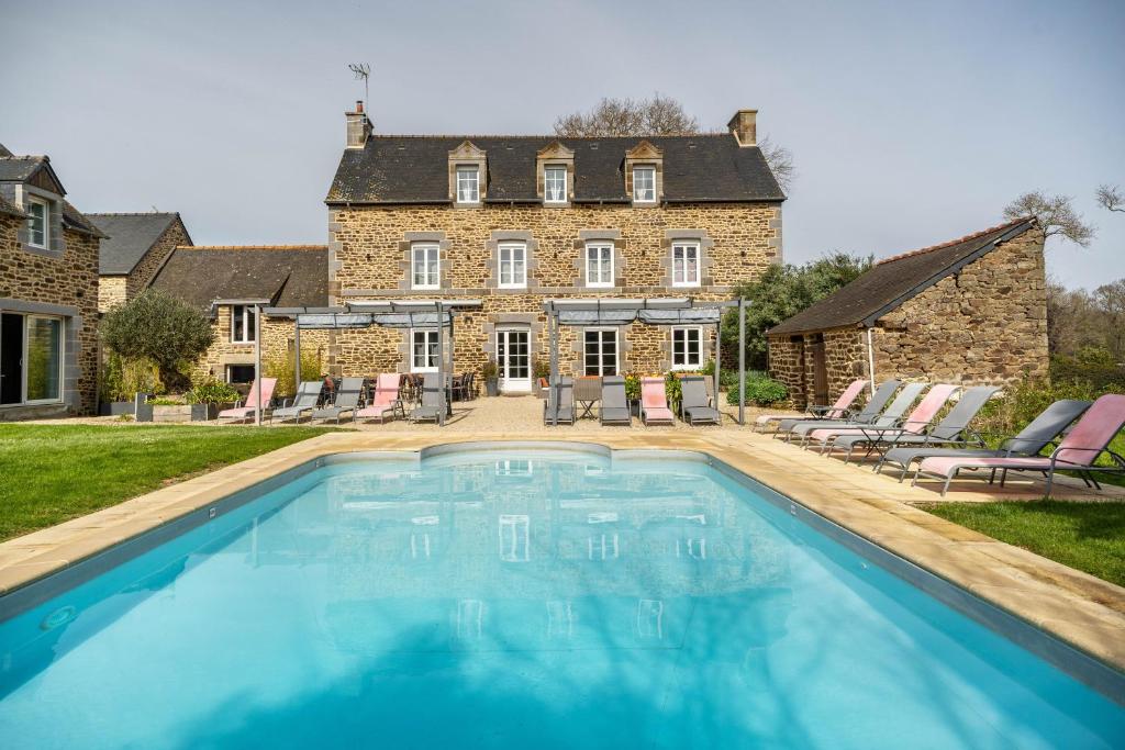 a large swimming pool in front of a house at Gîte Les Hervelines in Pleudihen-sur-Rance
