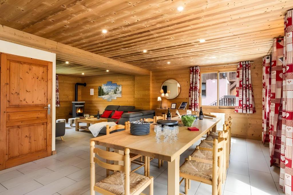 a kitchen and living room with a wooden ceiling at Chalet Snow Mountain in Le Bettaix