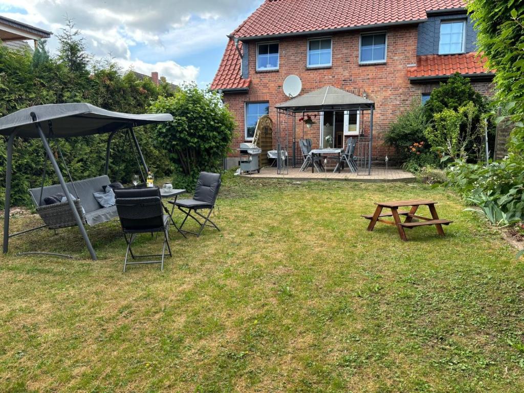 a backyard with a table and chairs and an umbrella at Heiderast Wipperau in Oetzen