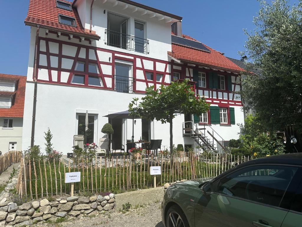 a house with a car parked in front of it at Ferienwohnung Seescheune in Bodman-Ludwigshafen