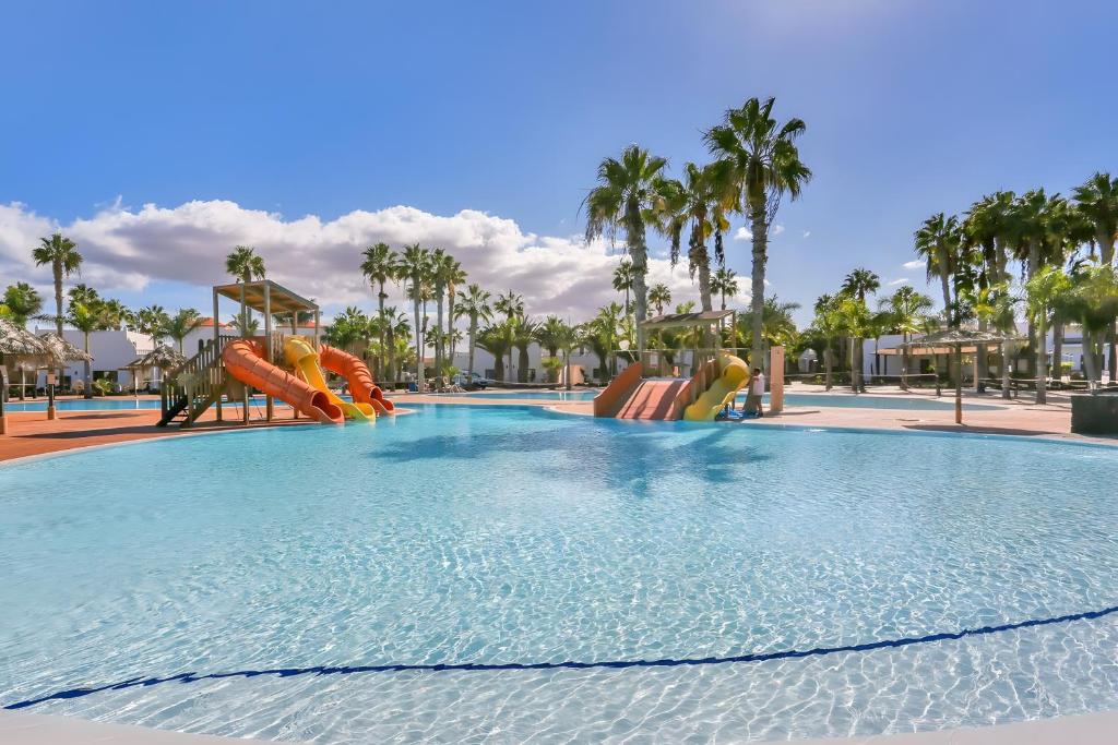 a large swimming pool with slides at a resort at Oasis Duna _ Casa Martineli Pool in Corralejo