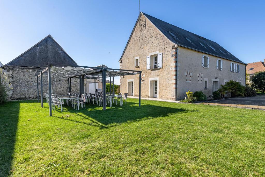 a garden with tables and chairs in front of a building at Gîte De L'orchidée in Saint-Épain