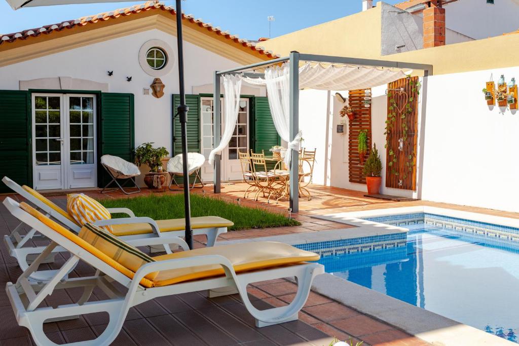 a group of chairs sitting next to a swimming pool at Casa de Jardim in Ponte de Sor