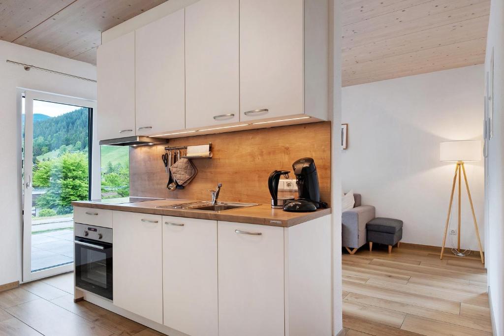 a kitchen with white cabinets and a sink at Wanderlust in Todtnau
