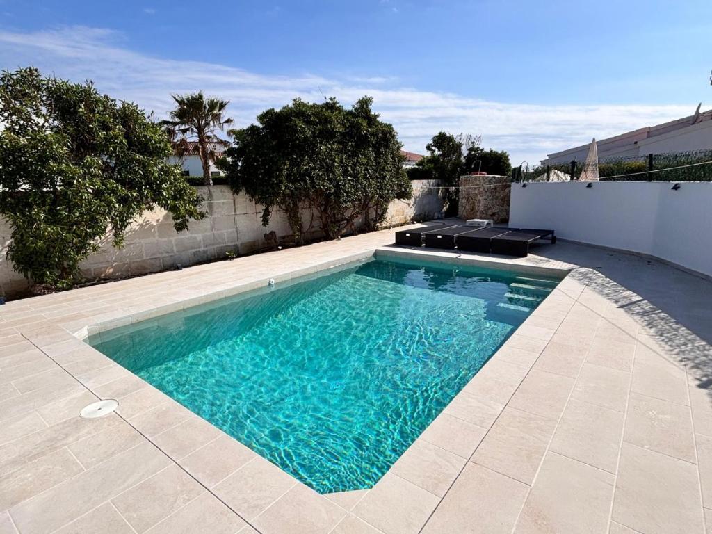 a swimming pool with blue water in a backyard at Casa Menorquina Son Moix in Ciutadella