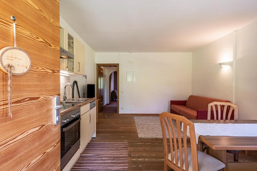 a kitchen and living room with a table and a couch at Sabina Dolomites Piz in Alpe di Siusi