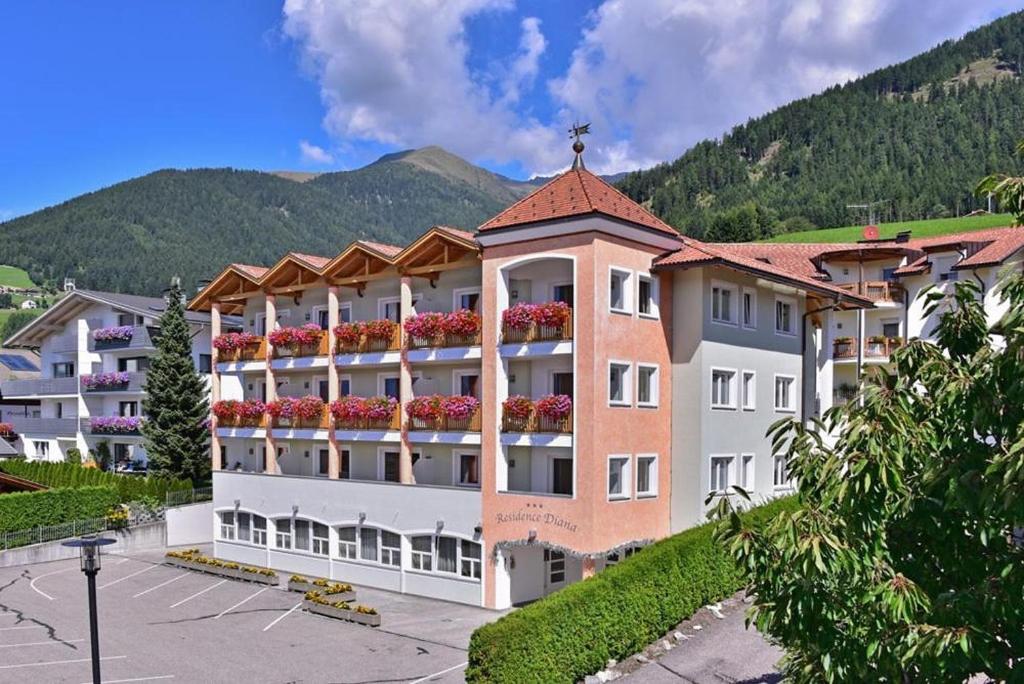 a large apartment building with flowers on the balconies at Residence Diana Apartment 303 in Terento