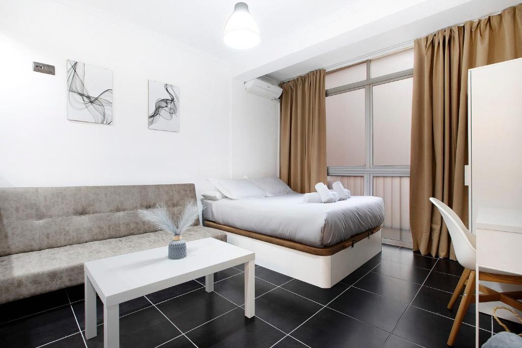 a bedroom with a bed and a couch and a table at Estudio centro de Torremolinos in Torremolinos