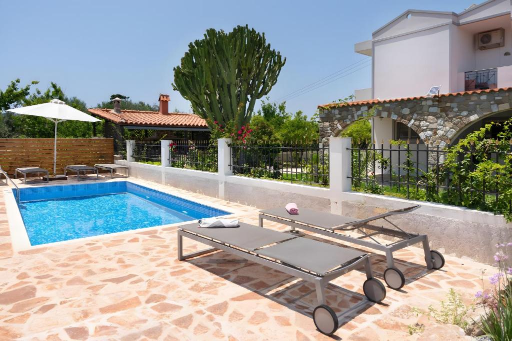 a pool with a table next to a house at Villa Elysian in Antimácheia