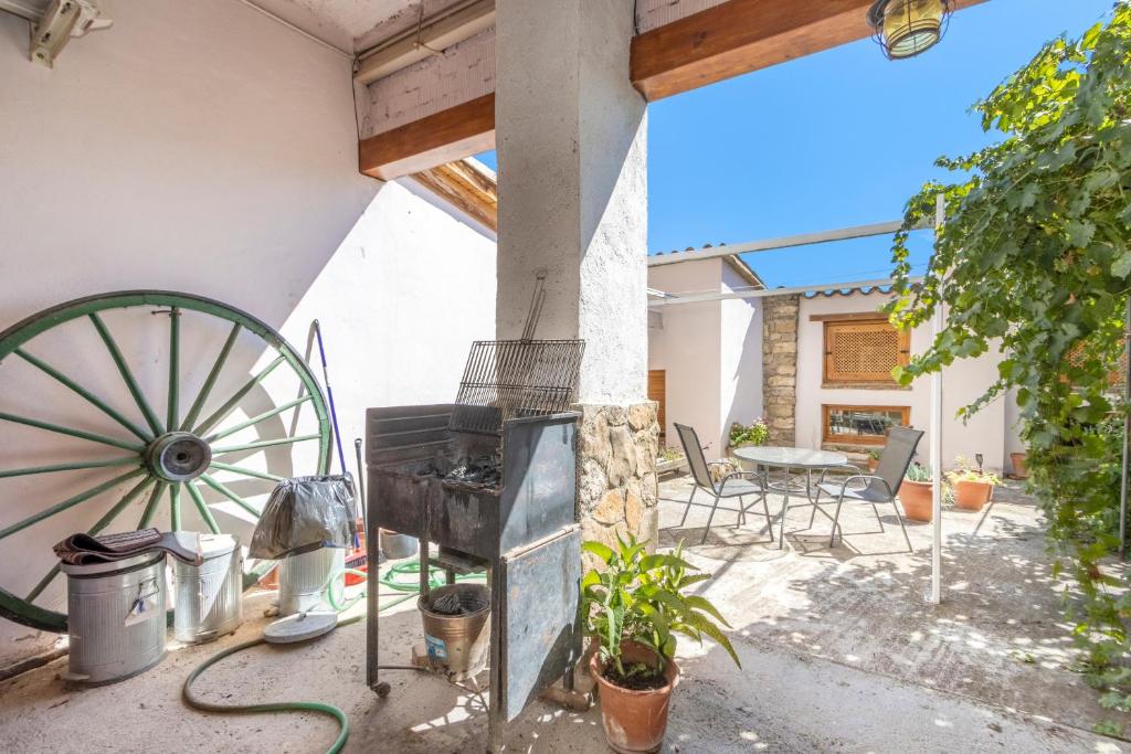 a patio with aoked wheel and a table and chairs at Casa Ramona in Conques