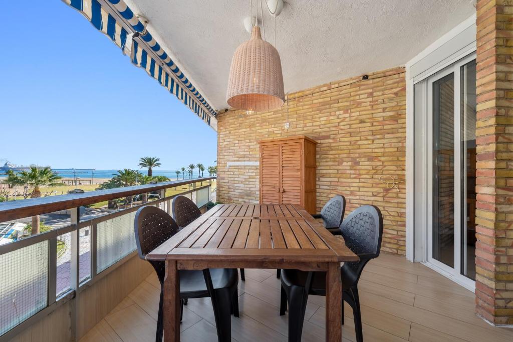 a wooden table and chairs on a balcony at Tirreno 304 in La Pineda