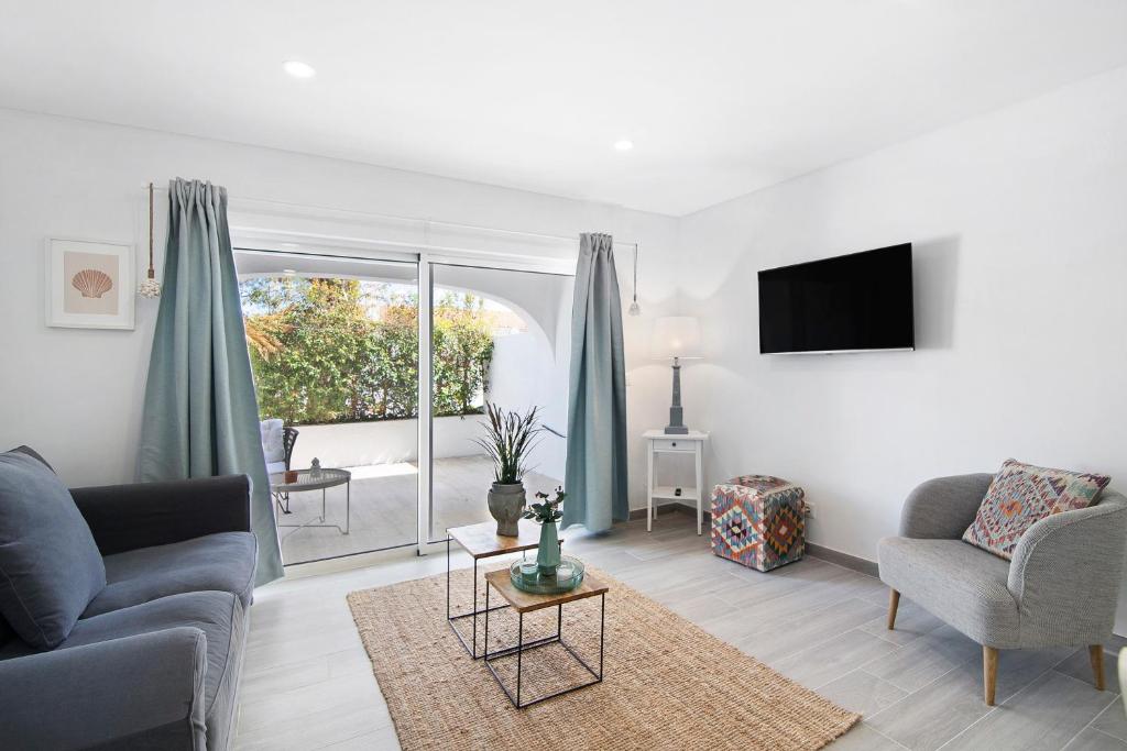 a living room with a couch and a tv at Apartamento Acácia in Vale do Lobo