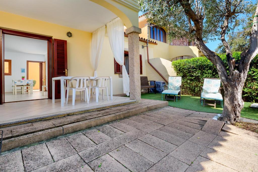 a patio with a table and chairs and a tree at Villa Bianca in San Teodoro