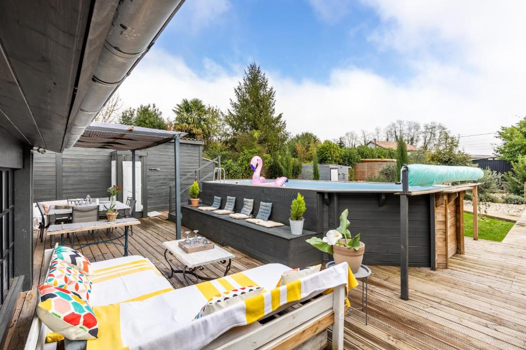 a backyard with a deck with a swimming pool at Demeure en pierre avec piscine in Vertheuil-en-Médoc