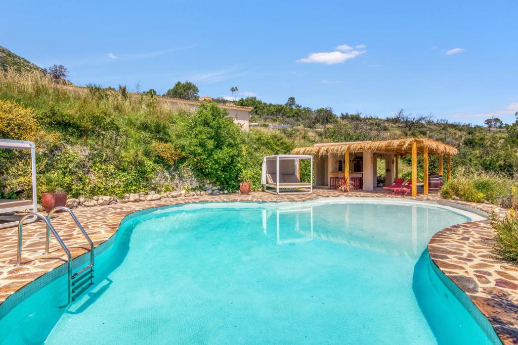 a swimming pool in a yard with a house at Bed and Breakfast La Ruta Naranja in Adsubia