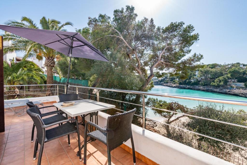 a table and chairs on a balcony with a view of the water at Bungalow Cala Dor 27 in Cala d´Or
