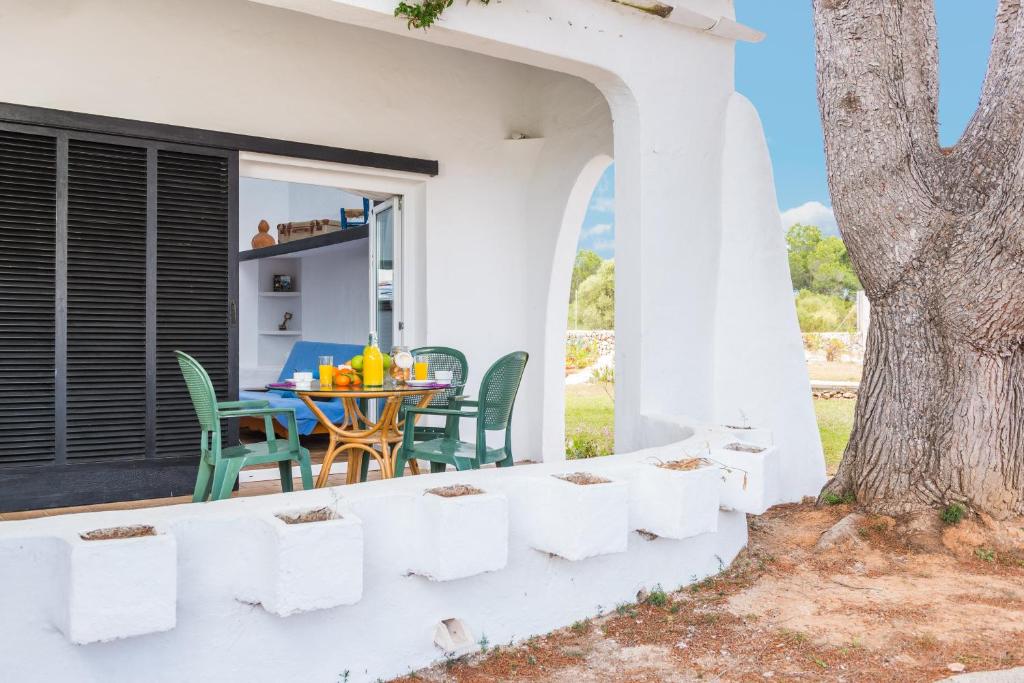a patio with a table and chairs and a tree at Cala Serena Beach 6 in Felanitx