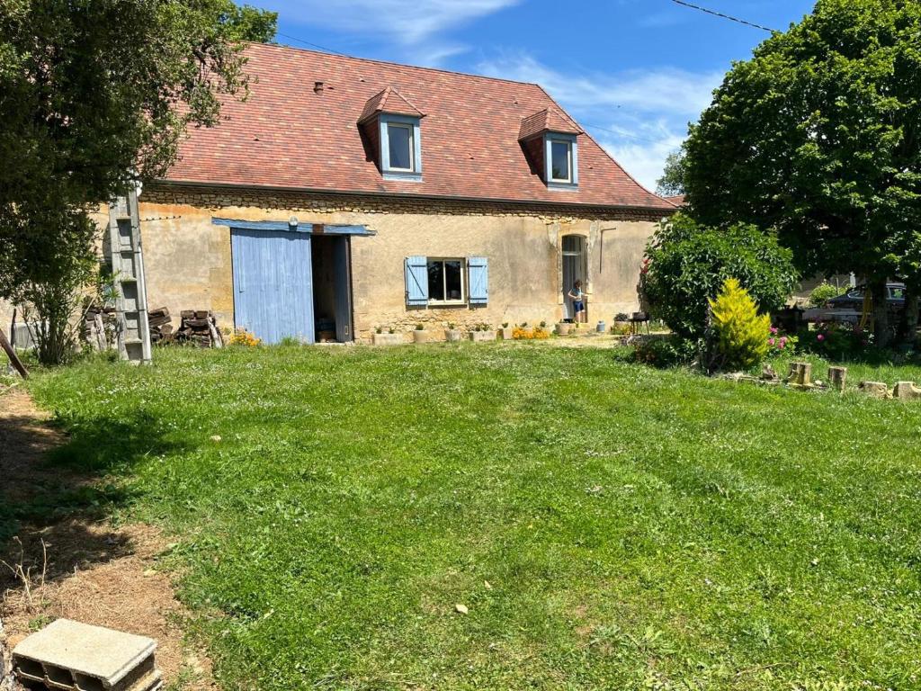 a house with a grass yard in front of it at Belle Ferme Périgourdine in Sainte-Foy-de-Longas