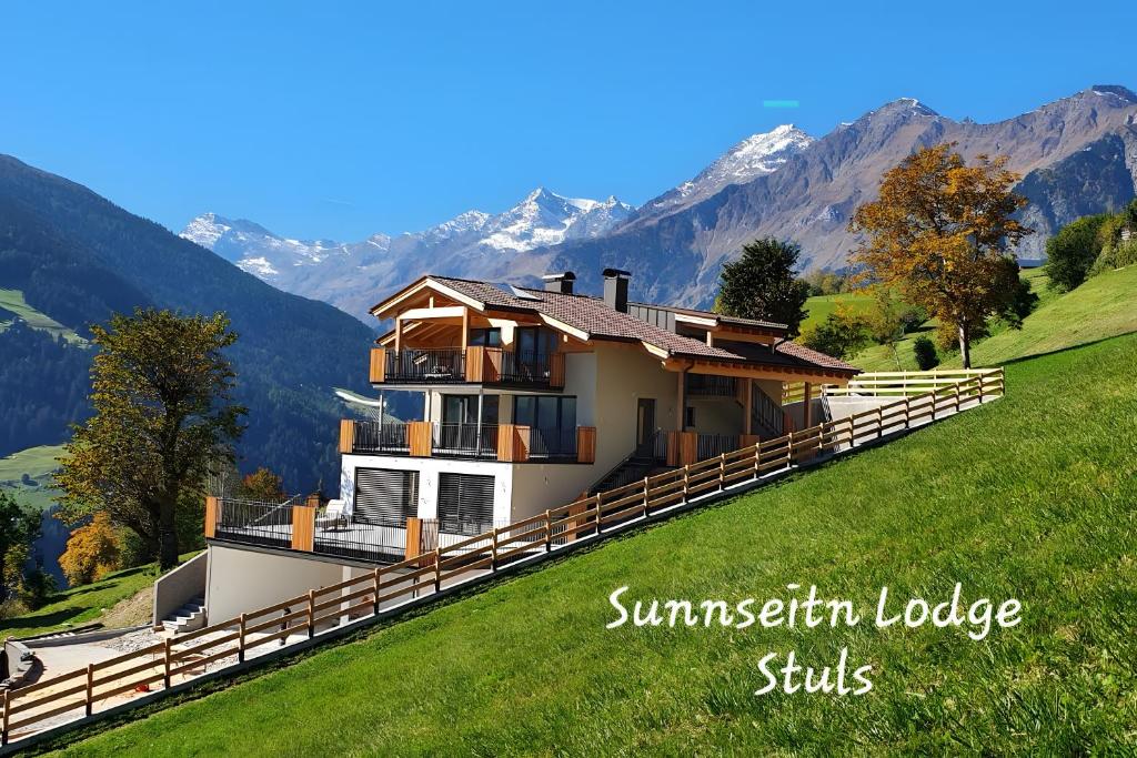 a house on a hill with mountains in the background at Sunnseitn Lodge Exclusive Panorama in Moso
