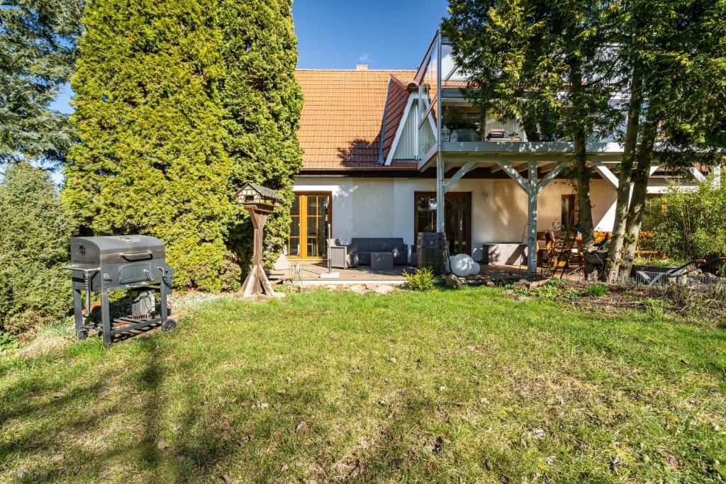 a house with a grill in the yard at Ferienwohnung Eichenhof in Blankensee