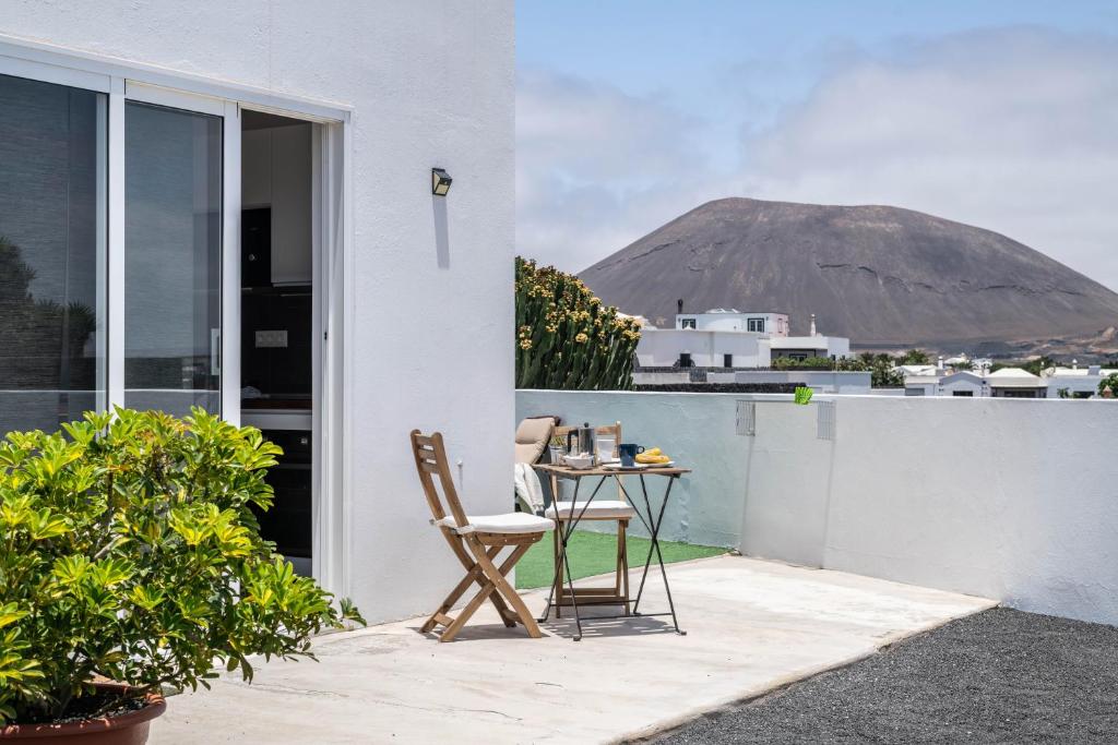 a table and chairs on a balcony with a view of a mountain at Casa Majina in El Islote