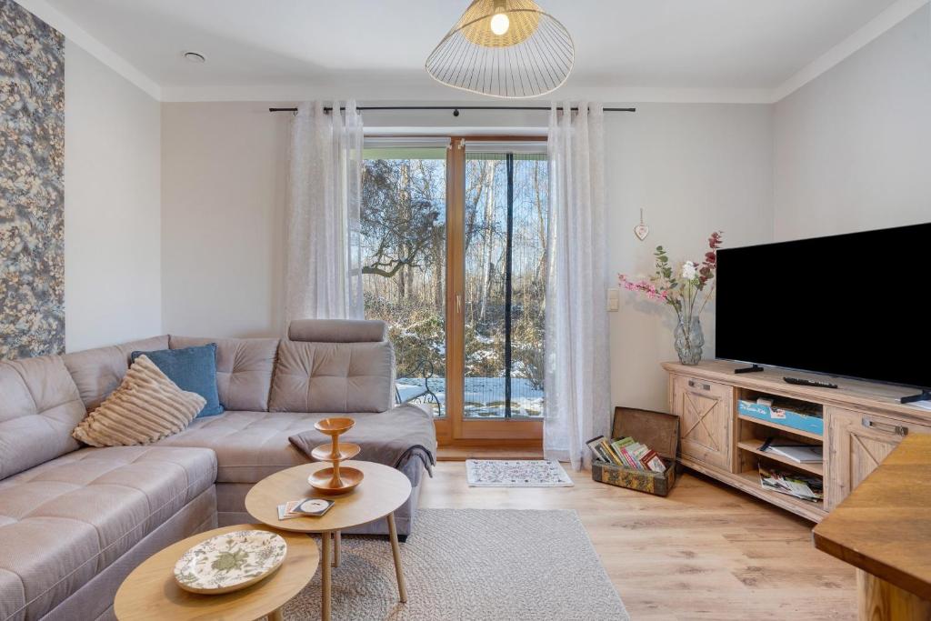 ein Wohnzimmer mit Sofa und Flachbildfernseher in der Unterkunft Spreequartier in Malschwitz