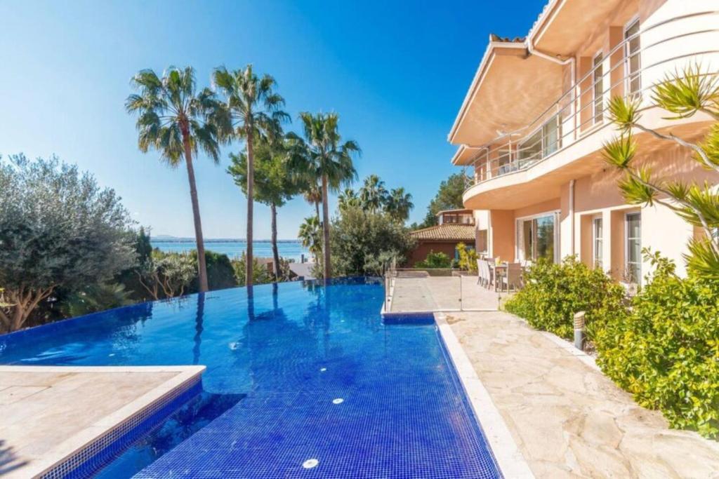 a swimming pool in front of a house at Alcanada Paradise in Alcudia