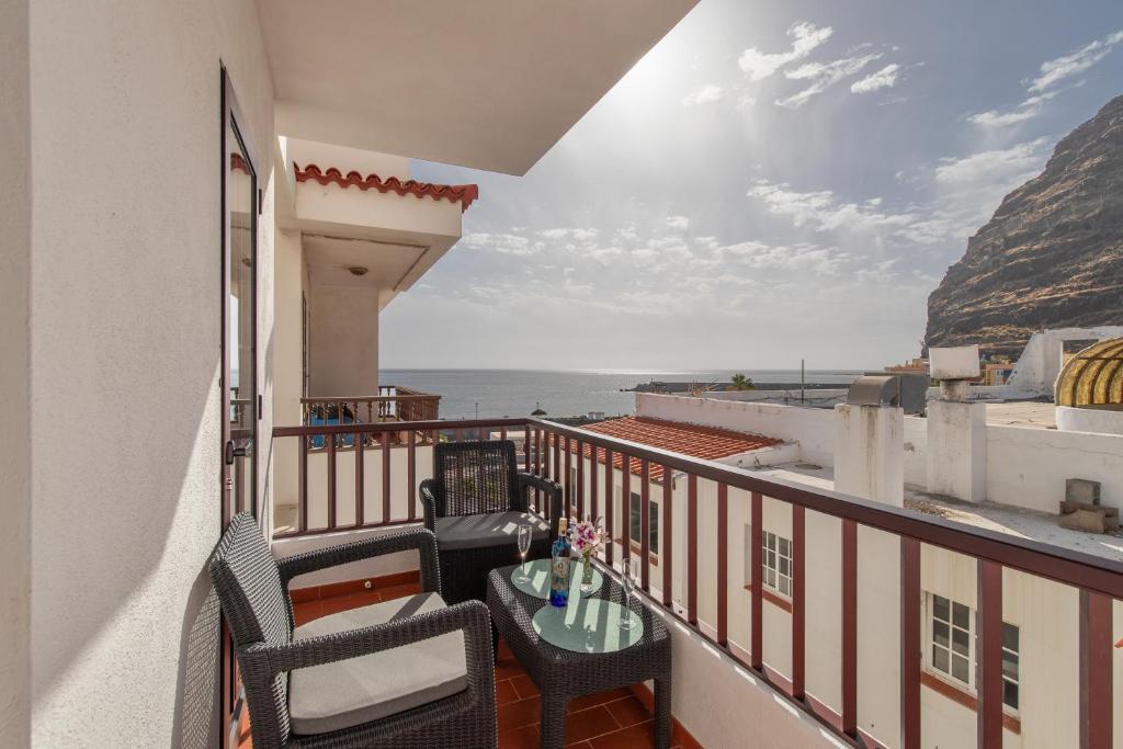 a balcony with a table and chairs and the ocean at Orion Beach in Puerto