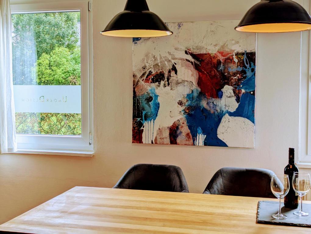 a dining room table with two chairs and a painting at Ferienwohnung Lichtenstein in Lichtenstein