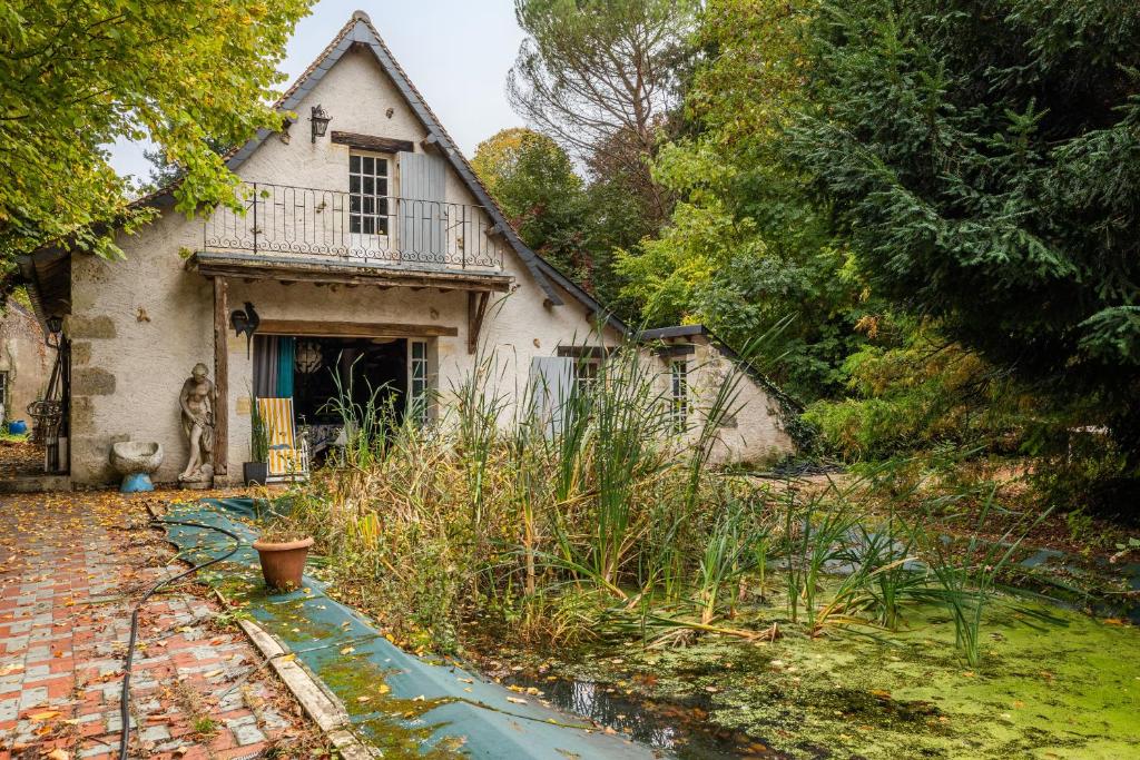 an old house with a porch and a yard at La Closerie du Cassereau in Vernou-sur-Brenne