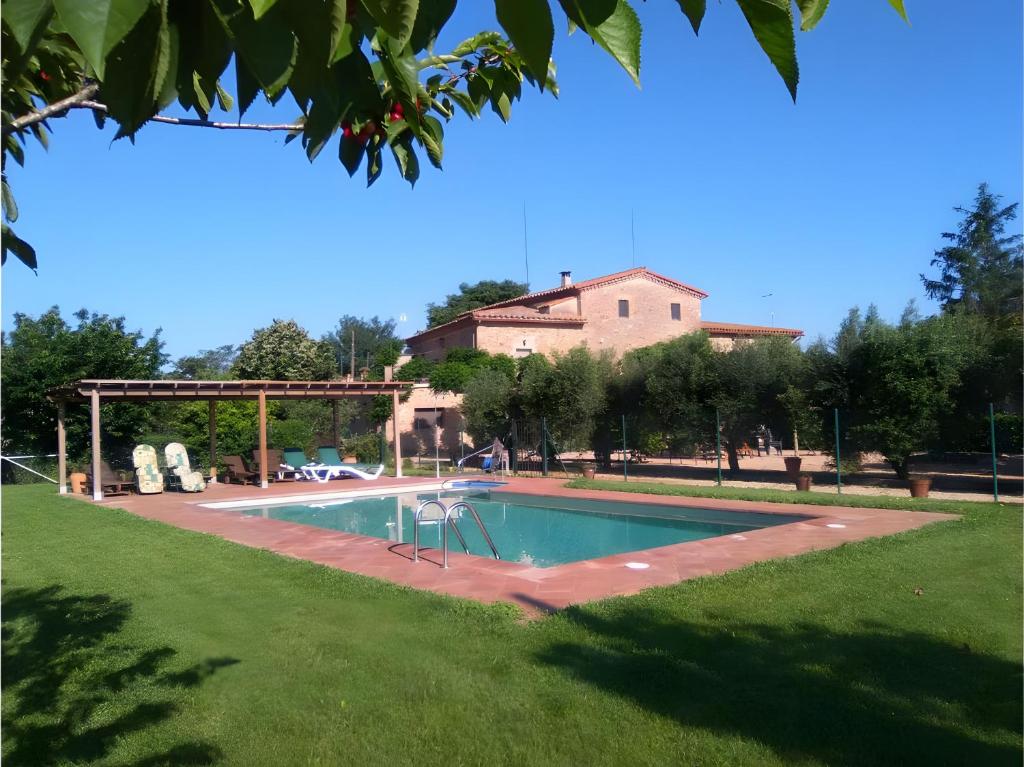 a swimming pool in a yard with a house in the background at Mas Pareta - La Parra 1 in Fonolleras