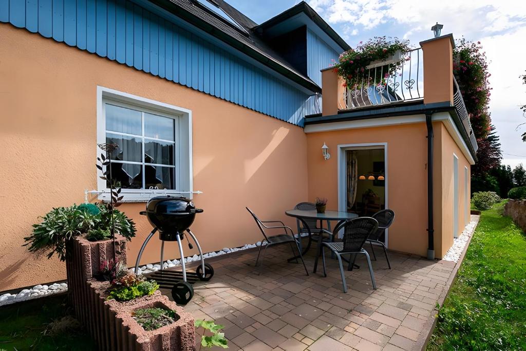 a patio with a table and chairs next to a house at Teichmühle - Vogtland Chalet in Bad Brambach