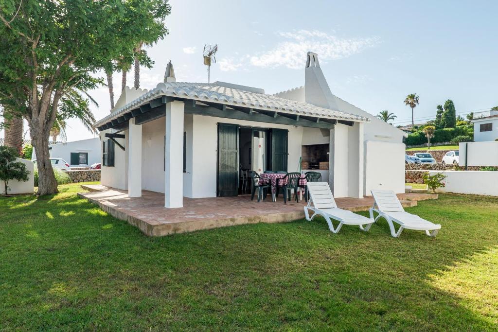 a small white house with chairs and a porch at Casa 4 P en Complejo Binisafua in Binisafua
