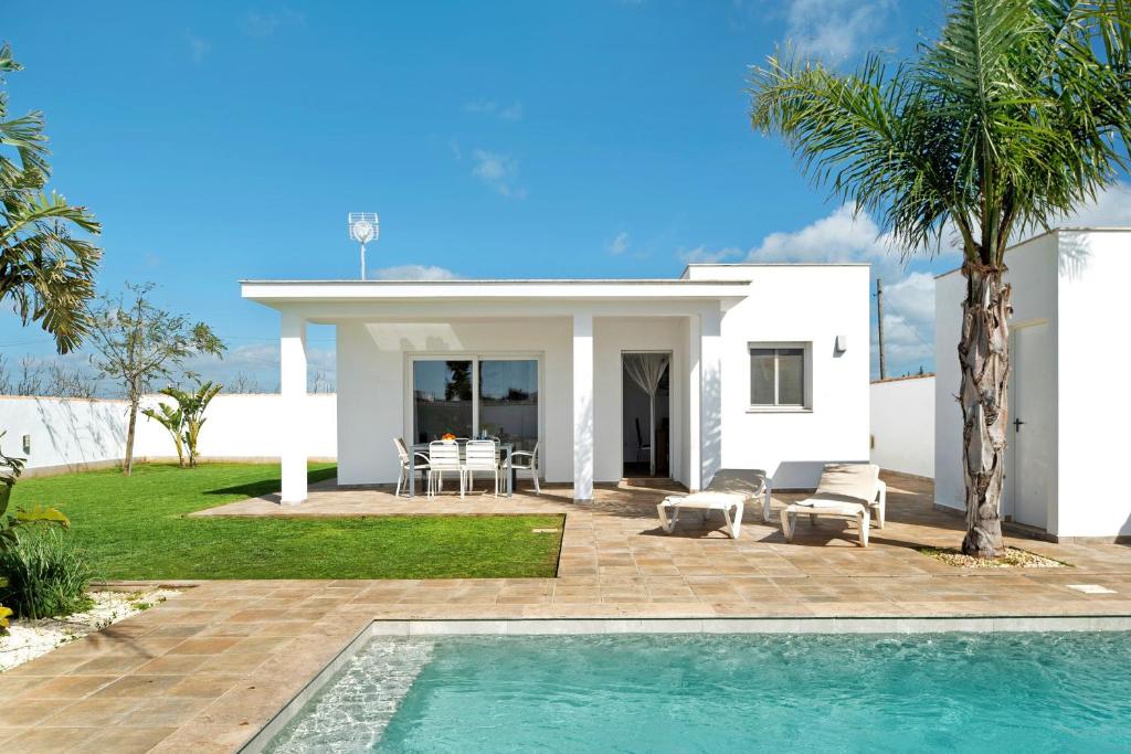 a villa with a swimming pool in front of a house at Casa Maria Jose in Cádiz