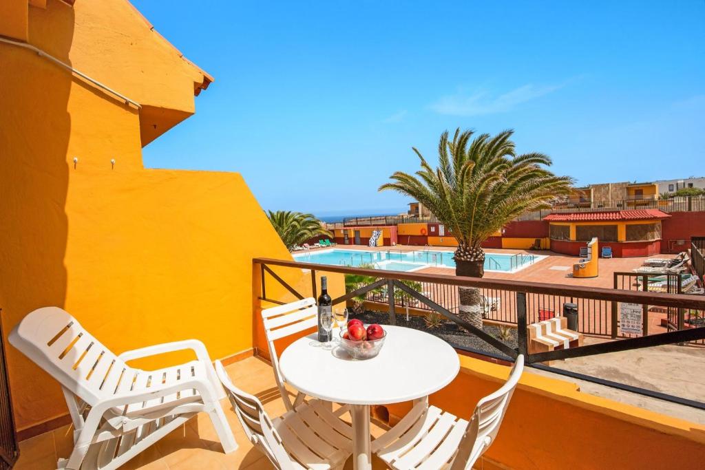 a balcony with a table and chairs and a pool at Surf Home Sea View in Costa de Antigua