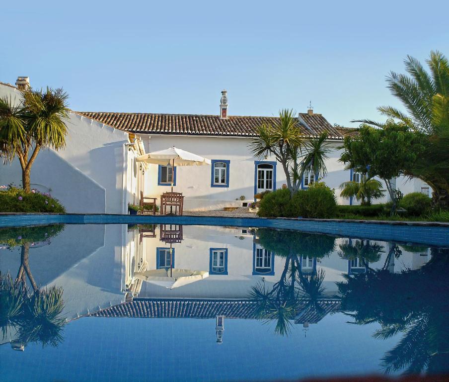 une maison et une piscine bordée de palmiers dans l'établissement Quinta Quinze, à Boliqueime