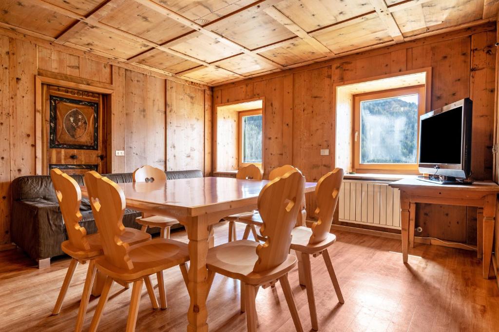 a dining room with a wooden table and chairs at Muncion Apparte in Pozza di Fassa