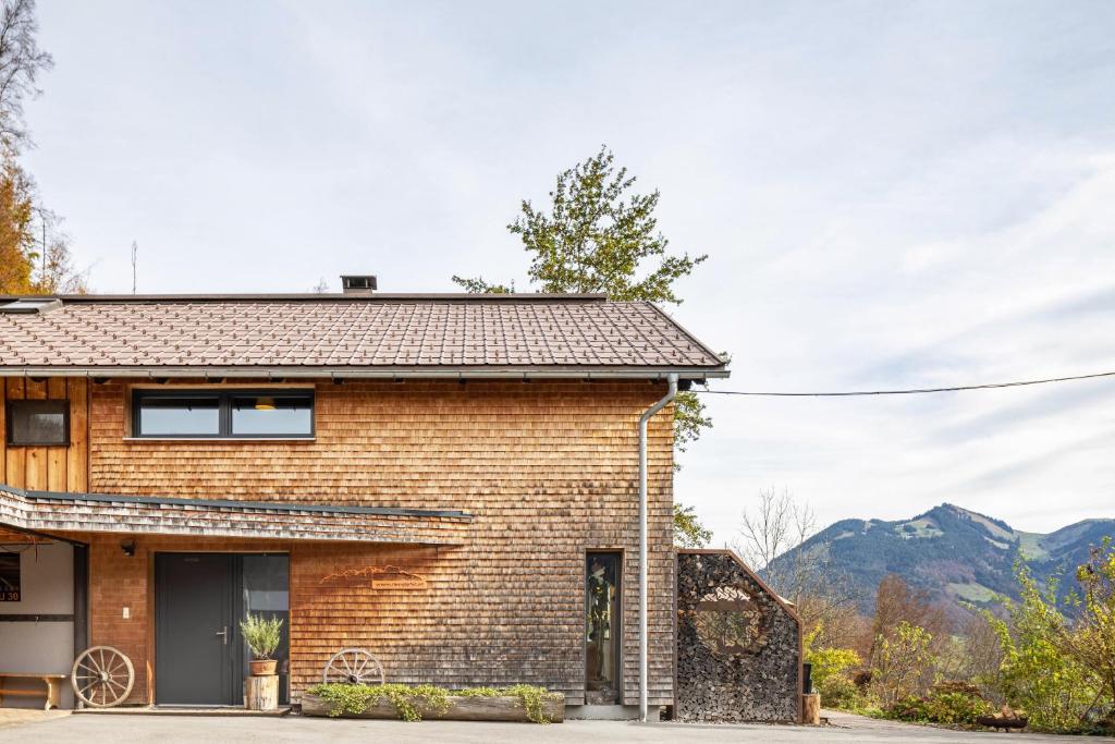 a brick house with mountains in the background at Ferienhaus am Berg in Hirschau