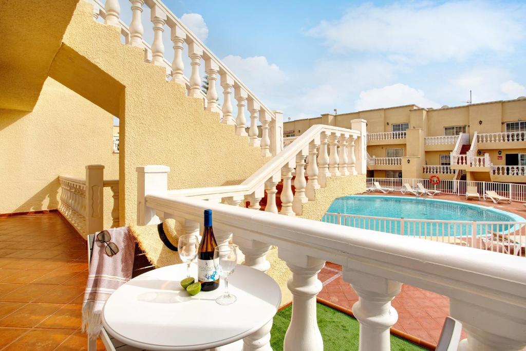 a balcony with a table with a bottle of wine at Liomor Luxury in Caleta De Fuste