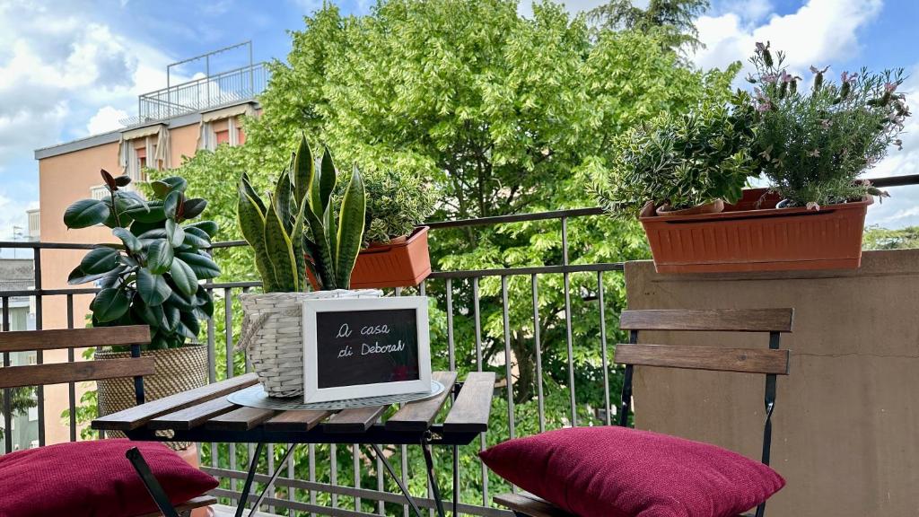 a computer sitting on a table on a balcony with potted plants at A casa di Deborah in Padova