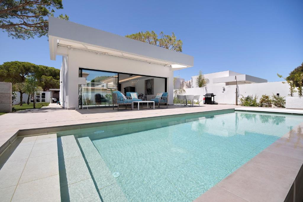 a swimming pool in front of a house at Lola Sea Villa in Novo Sancti Petri