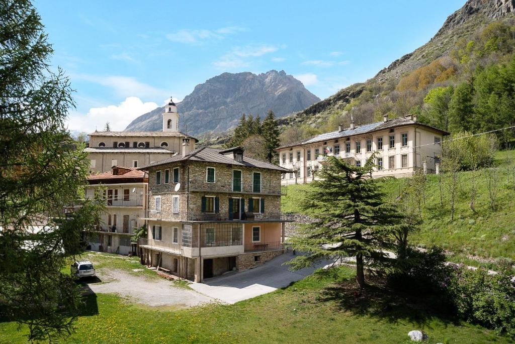 a group of buildings in front of a mountain at Alta Valle Maira C in Acceglio