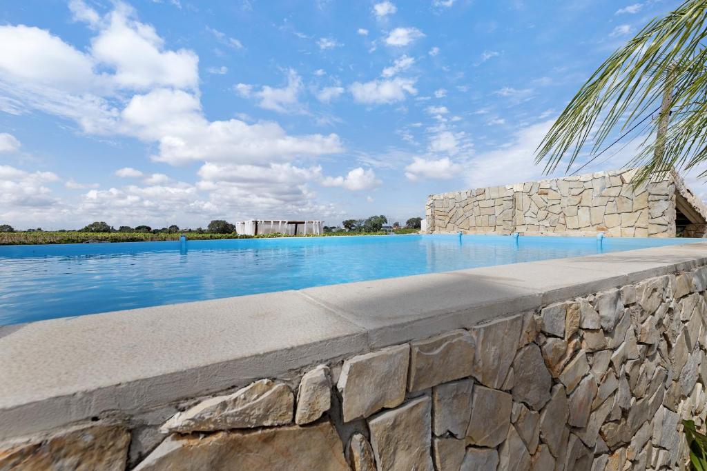 a stone retaining wall next to a swimming pool at Casa Verdelho in Palmela