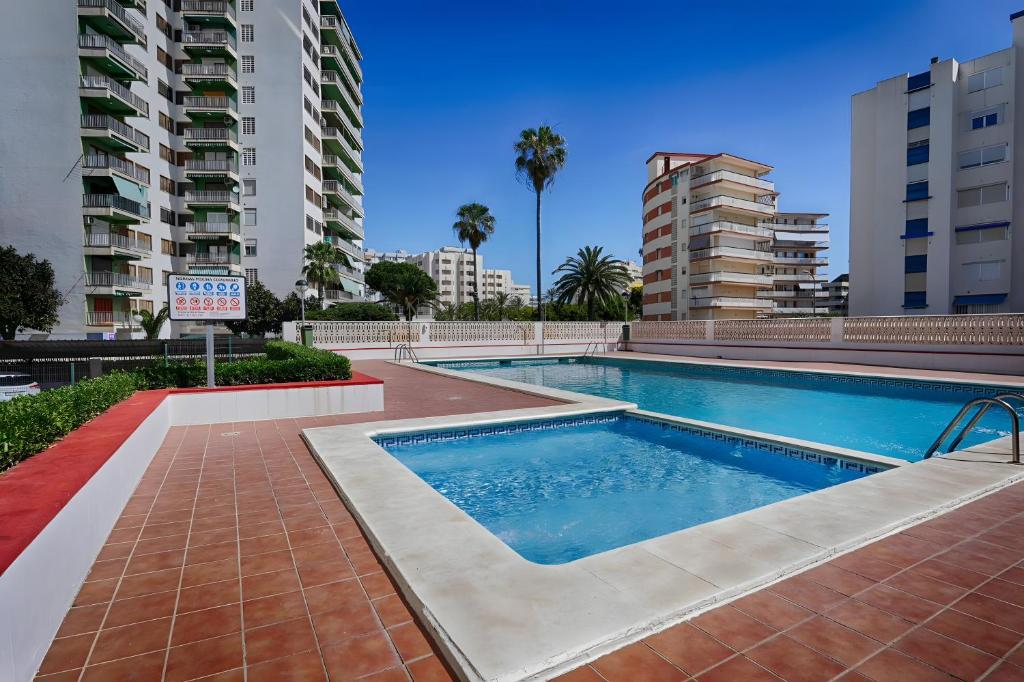 a swimming pool with buildings in the background at Brasil Mar in Playa de Gandia