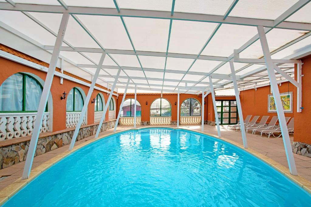 an indoor swimming pool with a large blue swimming pool at Finca Tropical in Ingenio