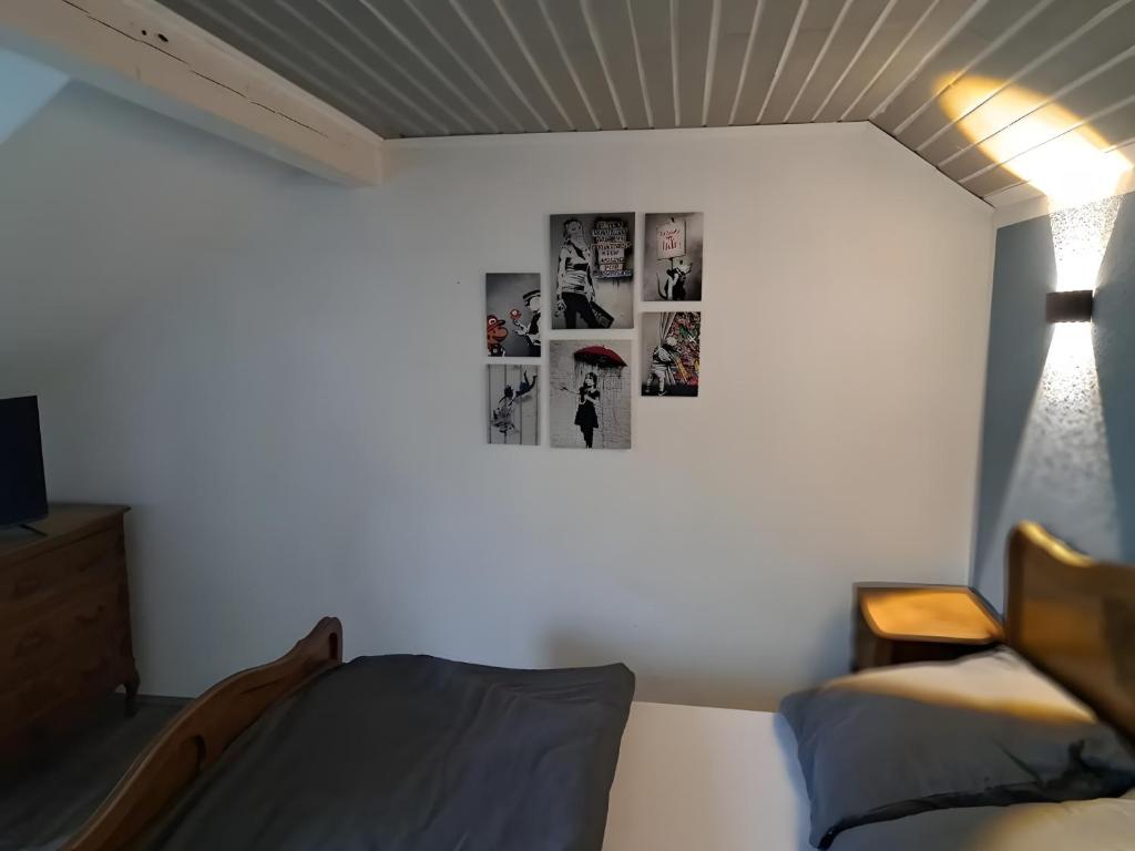 a bedroom with a bed and pictures on the wall at Zimmer in Müsch nahe Nürburgring in Müsch