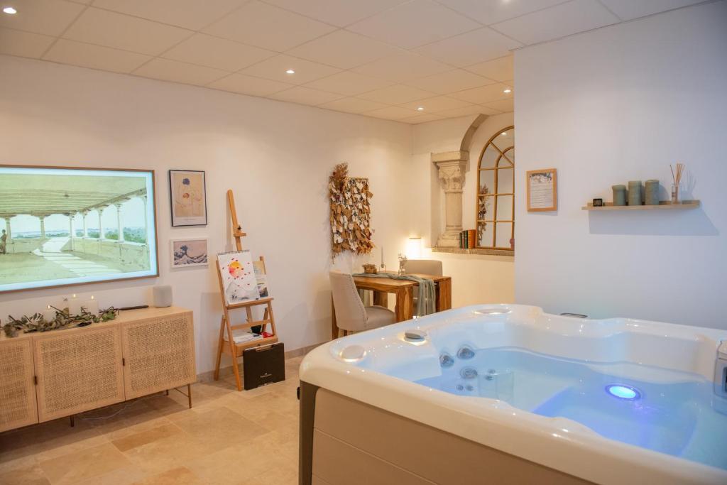 a large bathroom with a large tub in a room at Couvent des Cordelières option spa in Vezins