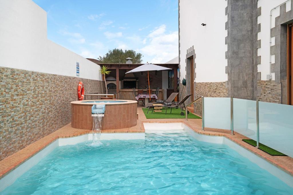 a swimming pool with a water fountain in a building at Casa Barriguita in Yaiza