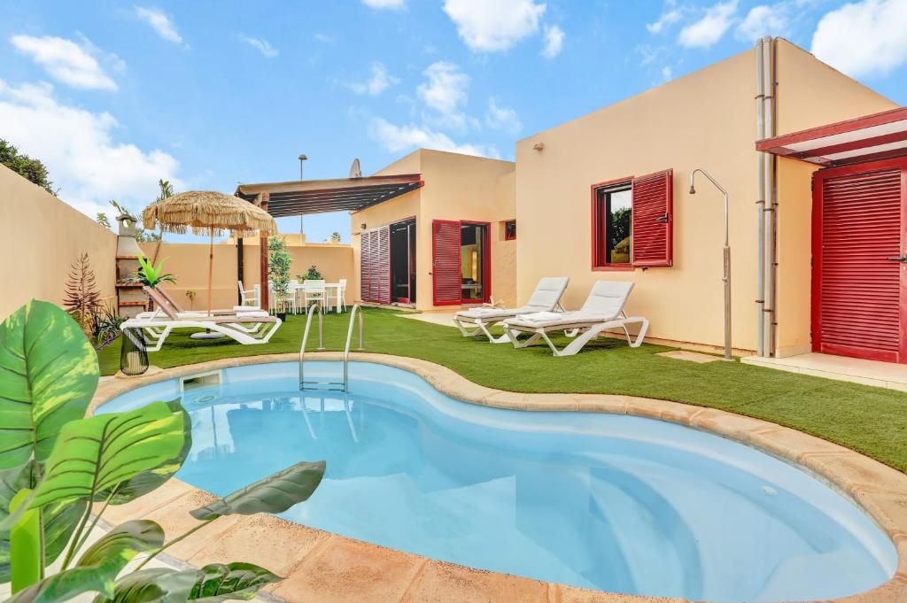 a villa with a swimming pool in a yard at Casa Mavadel in La Oliva